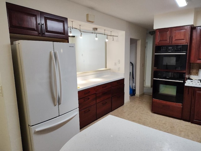 kitchen with white fridge and black double oven