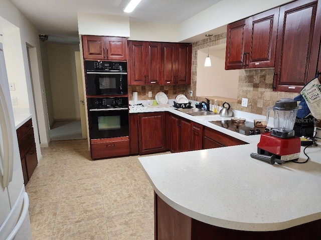 kitchen with sink, double oven, kitchen peninsula, pendant lighting, and decorative backsplash