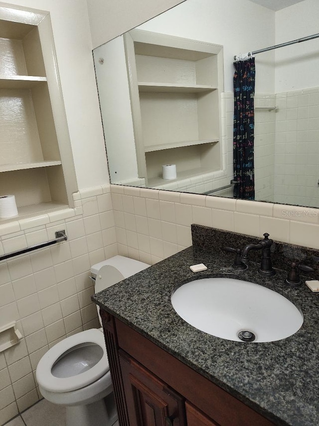 bathroom with built in shelves, vanity, tile walls, and toilet