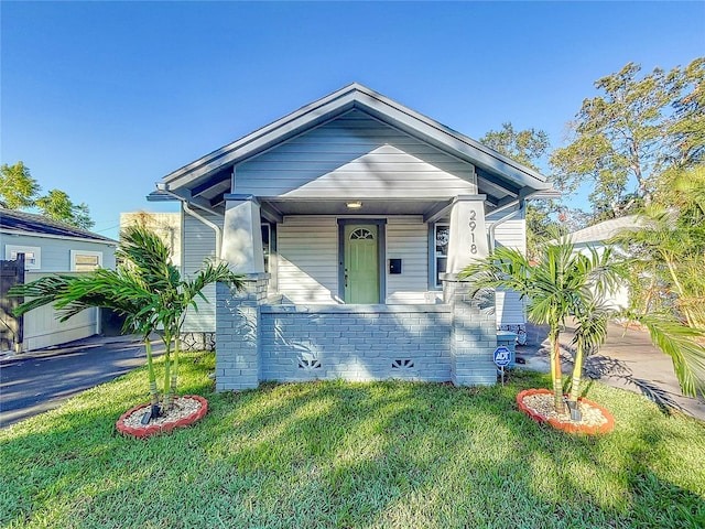 bungalow-style home with a front yard