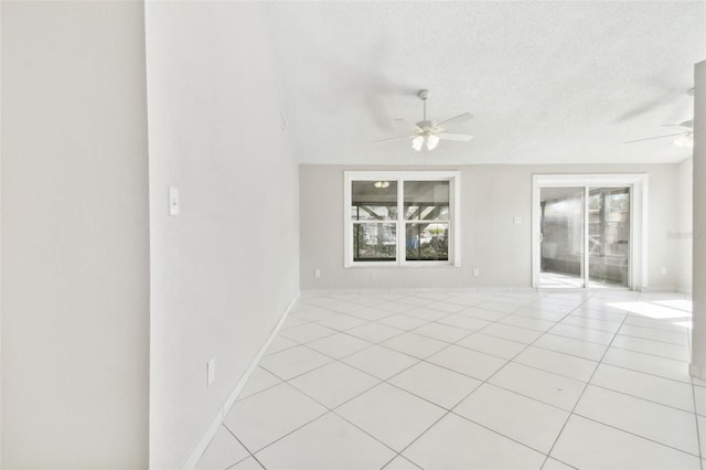 empty room with ceiling fan, a healthy amount of sunlight, and a textured ceiling