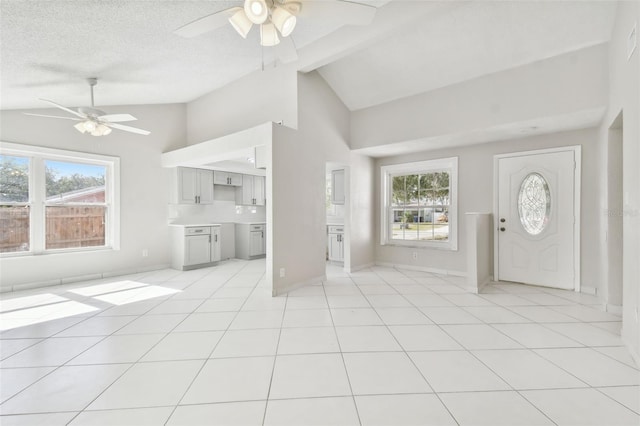 foyer entrance featuring a wealth of natural light, ceiling fan, light tile patterned flooring, and a textured ceiling