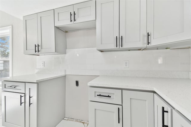 kitchen featuring decorative backsplash and light stone counters