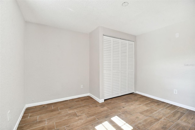 unfurnished bedroom with a closet, hardwood / wood-style floors, and a textured ceiling