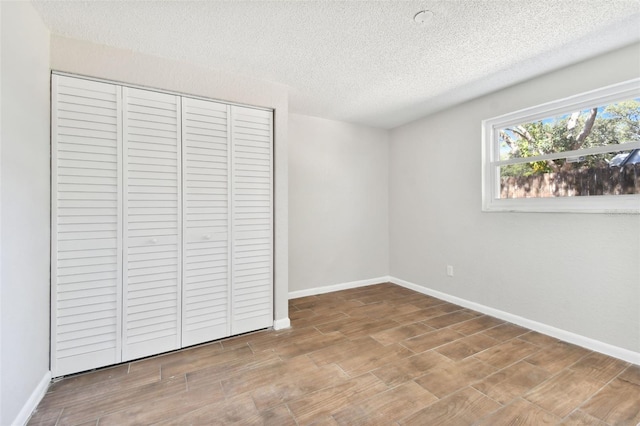 unfurnished bedroom featuring a textured ceiling and a closet