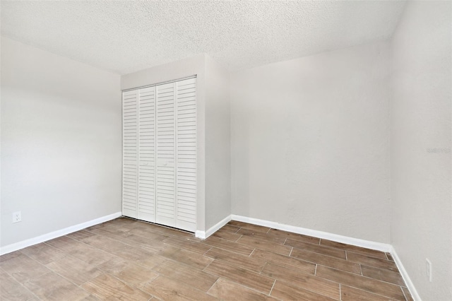 unfurnished bedroom with a closet, a textured ceiling, and hardwood / wood-style flooring