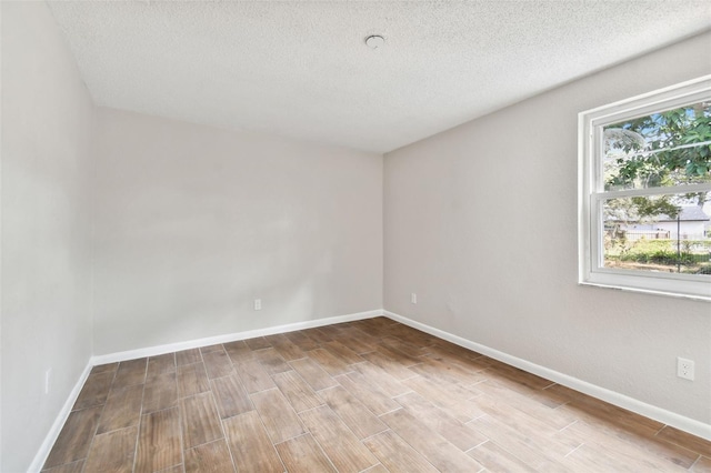 unfurnished room with light hardwood / wood-style floors and a textured ceiling