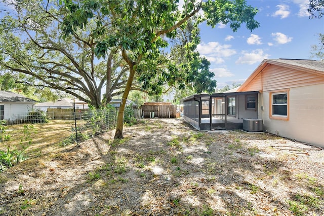 view of yard featuring central air condition unit and a sunroom