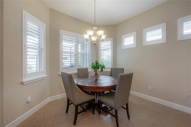 dining room with light tile patterned floors, a wealth of natural light, and an inviting chandelier