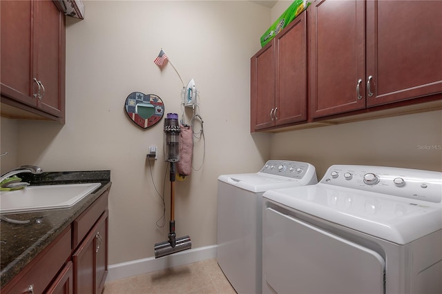 laundry room featuring cabinets, light tile patterned floors, separate washer and dryer, and sink