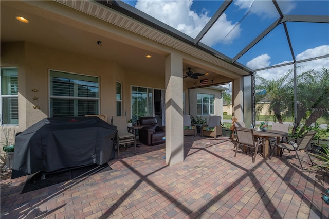 view of patio with ceiling fan, glass enclosure, and grilling area