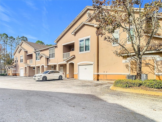 multi unit property featuring a garage and a balcony