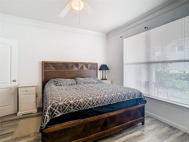 bedroom with ceiling fan, hardwood / wood-style floors, and crown molding