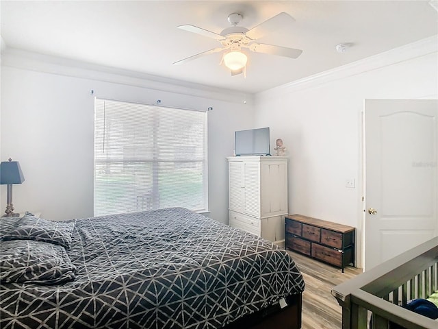 bedroom with ceiling fan, crown molding, and light hardwood / wood-style floors