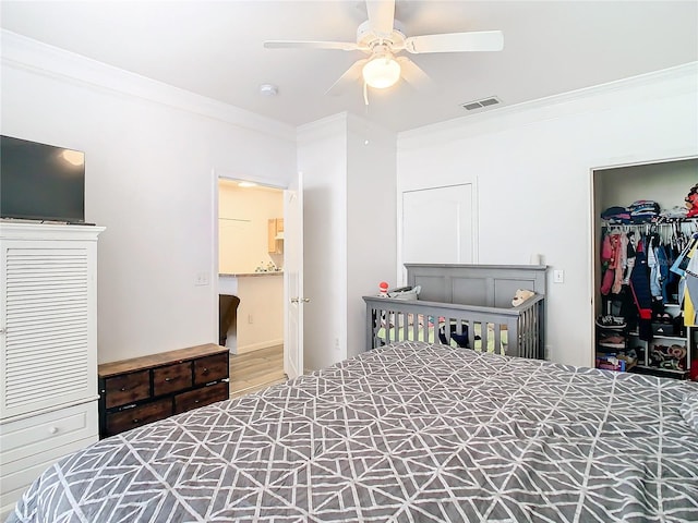 bedroom with hardwood / wood-style floors, a closet, ornamental molding, and ceiling fan