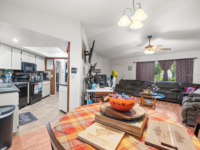 dining space with ceiling fan with notable chandelier, a textured ceiling, and light hardwood / wood-style flooring