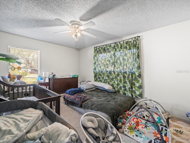 carpeted bedroom with ceiling fan and a textured ceiling