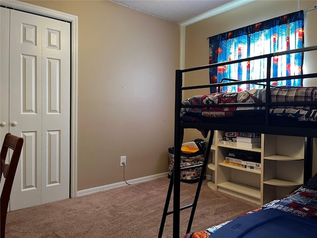 bedroom with a textured ceiling, carpet floors, and a closet