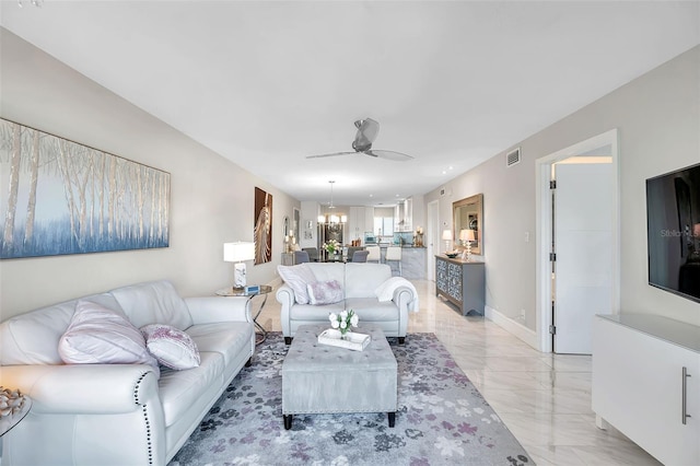 living room featuring ceiling fan with notable chandelier