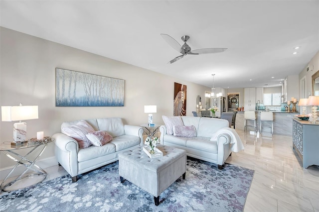 living room with ceiling fan with notable chandelier