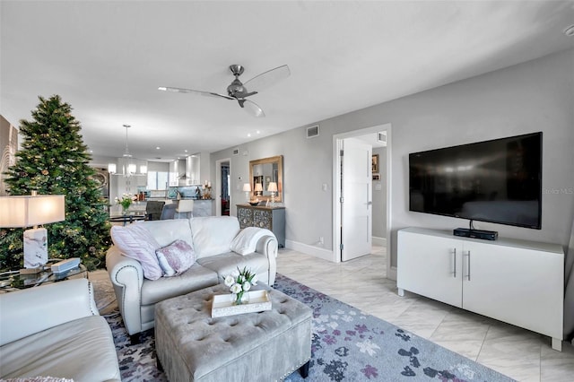 living room featuring ceiling fan with notable chandelier