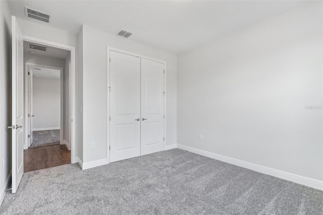 unfurnished bedroom with light carpet and a closet