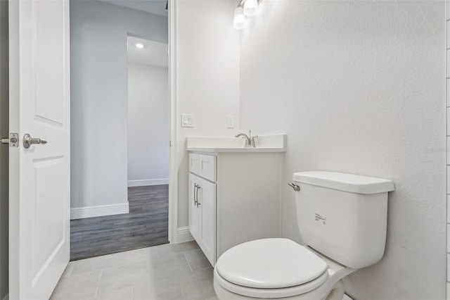 bathroom featuring tile patterned flooring, vanity, and toilet