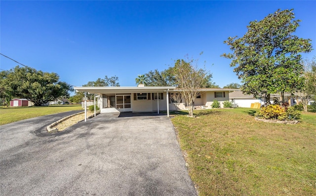 single story home featuring a front lawn and a carport