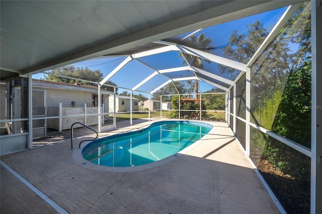 view of pool with glass enclosure and a patio