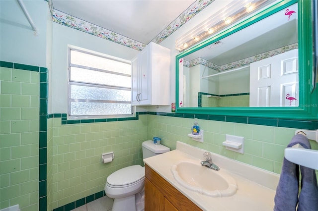 bathroom featuring toilet, vanity, tile walls, and walk in shower