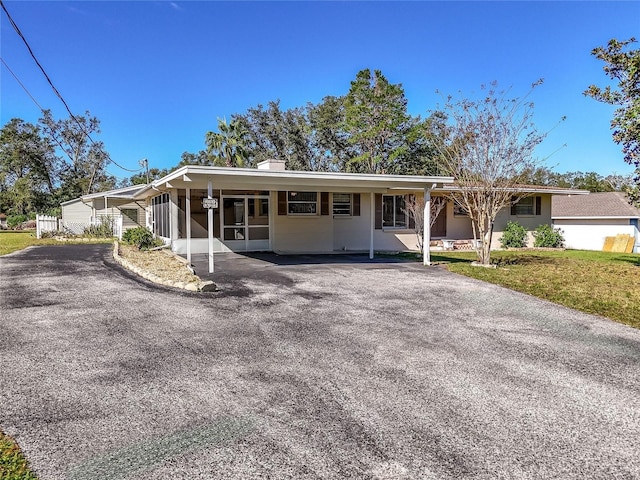 view of front of property featuring a front yard and a carport