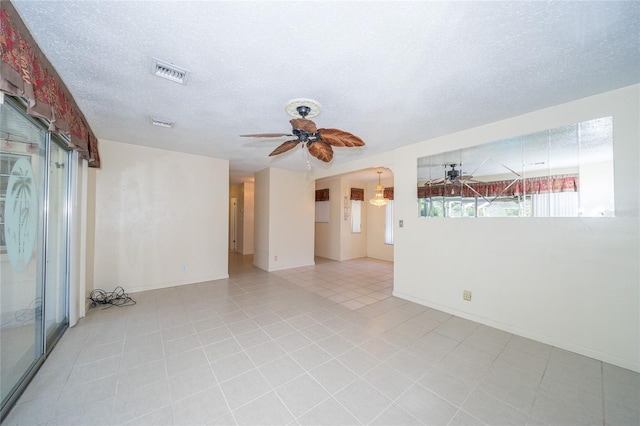 spare room with ceiling fan, light tile patterned flooring, and a textured ceiling