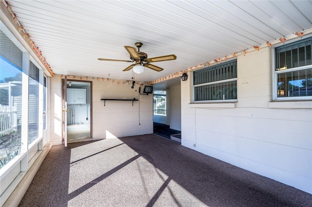 unfurnished sunroom featuring ceiling fan