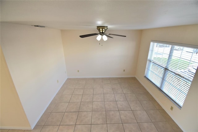 empty room with ceiling fan and light tile patterned floors