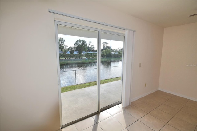 doorway with a water view and light tile patterned flooring