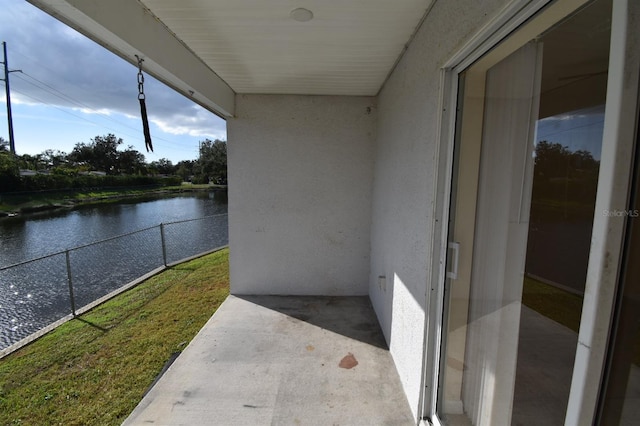 view of patio / terrace with a balcony and a water view