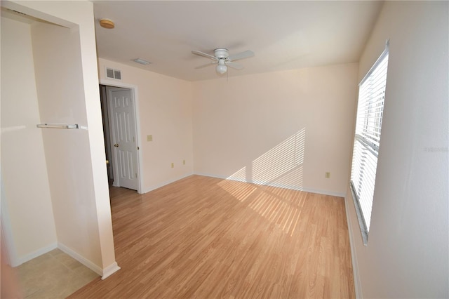 empty room with ceiling fan and light hardwood / wood-style floors