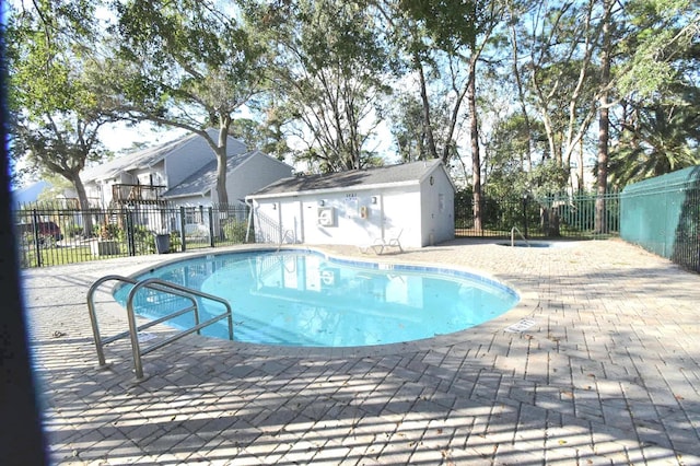 view of swimming pool with an outbuilding and a patio