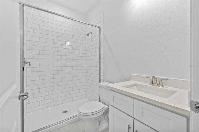 bathroom featuring tiled shower, vanity, and toilet