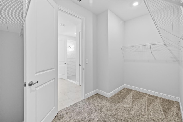 spacious closet featuring light carpet