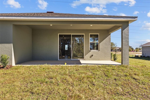 rear view of house featuring a yard and a patio