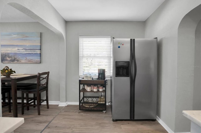 kitchen featuring hardwood / wood-style flooring and stainless steel refrigerator with ice dispenser