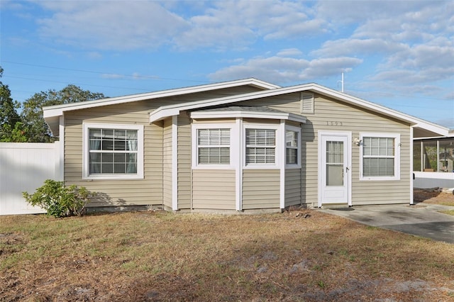 view of front of property featuring a sunroom and a front lawn