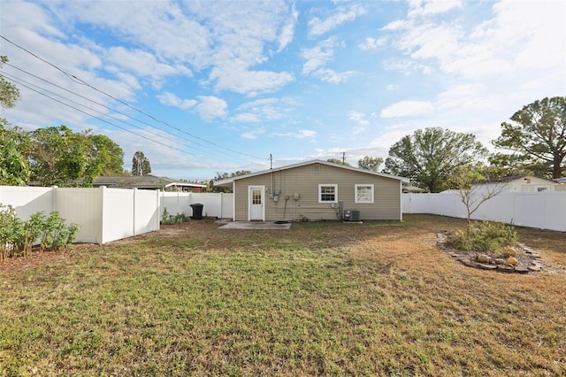 back of property featuring central air condition unit and a lawn