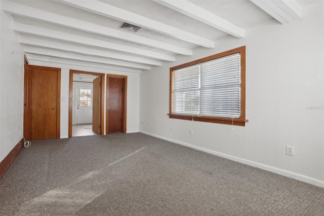 unfurnished bedroom featuring beam ceiling and carpet