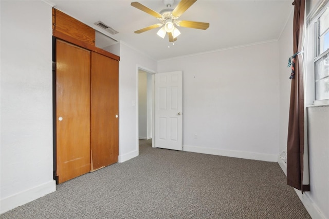 unfurnished bedroom with ceiling fan, a closet, carpet floors, and ornamental molding