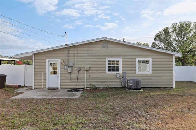 back of property featuring a lawn, a patio area, and central AC