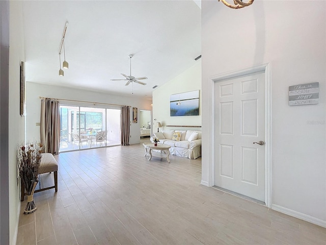 living area featuring ceiling fan, high vaulted ceiling, light wood-type flooring, and baseboards