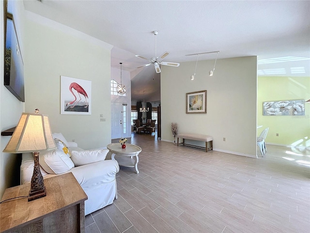 living room with a ceiling fan, high vaulted ceiling, baseboards, and wood finished floors