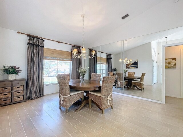 dining room featuring vaulted ceiling, an inviting chandelier, visible vents, and a healthy amount of sunlight